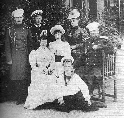 Η Ρωσική Αυτοκρατορική Οικογένεια σε μια επίσκεψή στο Fredensburg της Δανίας το 1893.  Από αριστερά προς δεξιά οι Μεγάλοι Δούκες Νικόλαος και Γεώργιος και οι Μεγάλες Δούκισσες Όλγα και Ξένια, καθήμενοι είναι η Αυτοκράτειρα Μαρί Φεοντορόβνα και ο Αυτοκράτορας Αλέξανδρος ΙΙΙ, με το Μεγάλο Δούκα Μιχαήλ καθήμενο μπροστά τους. 